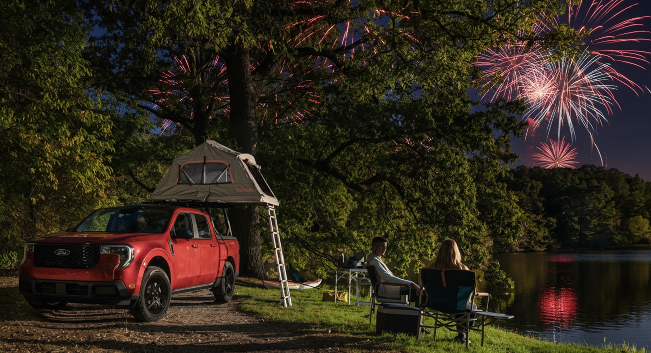 A Ford Maverick is parked on a campsite at night. A safari tent is assembled on the roof. A couple sits in deck chairs next to the vehicle watching fireworks in the sky.