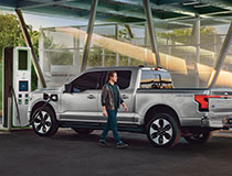 A person is standing next to a Ford F-150 Lightning