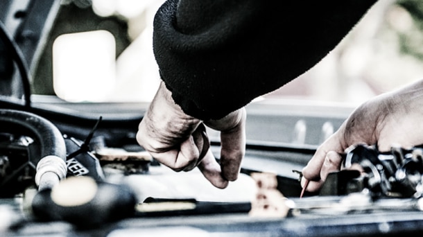 Closeup of technician's hands working on engine.