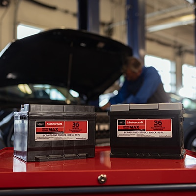 Motorcraft Batteries in a service bay with a technician in the background