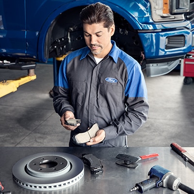 Technician working on brake parts on a service table