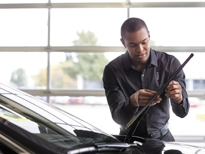 A Lincoln parked in the foregrround with the owner in the background