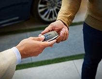 Client handing keys to technician by a vehicle