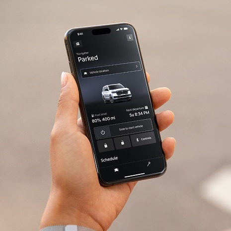 Someone is shown holding a mobile device in their hand displaying the Lincoln app.