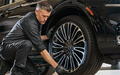 Technician working on a tire in a service bay.
