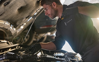 A Lincoln service tech checking vehicle oil.