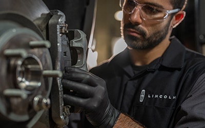 A Lincoln service tech checking brakes