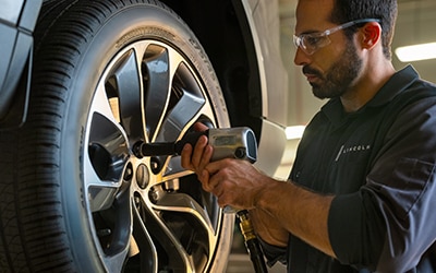 Lincoln technician working on a vehicle tire