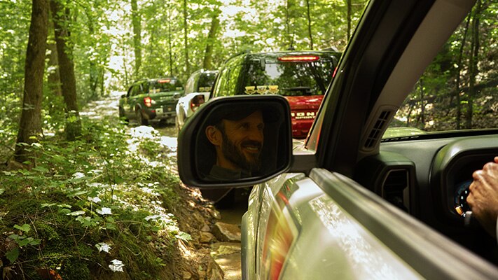 A group of off-roaders in their Bronco Sport® SUVs driving a trail.
