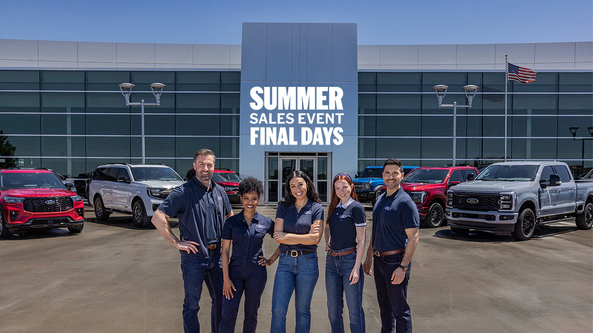 Ford Dealers stand in front of a Ford lineup at the dealership