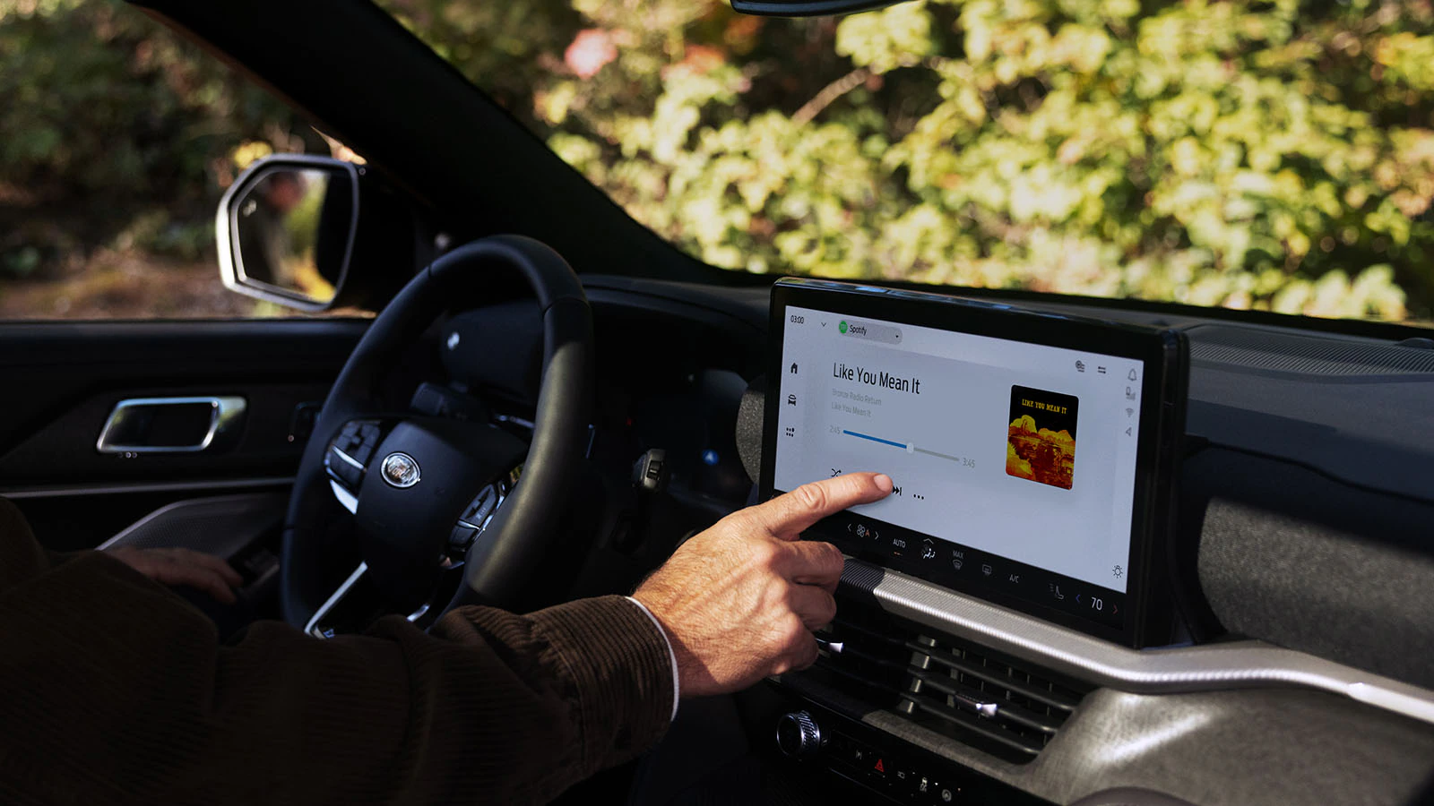 A passenger selects Alexa on the large center touchscreen inside the Explorer® SUV.
